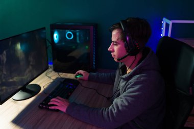 Video oyunlarına bayılırım. Çekici genç adam bilgisayarın başında oturup oyun oynarken rahatlıyor.