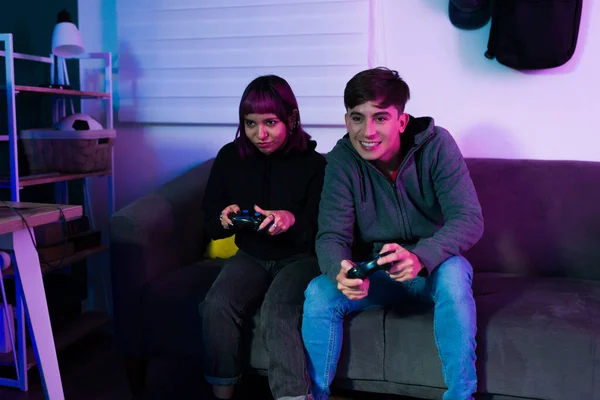 年轻女人和男人在一起玩电子游戏的时候 一边玩游戏 一边玩乐 — 图库照片