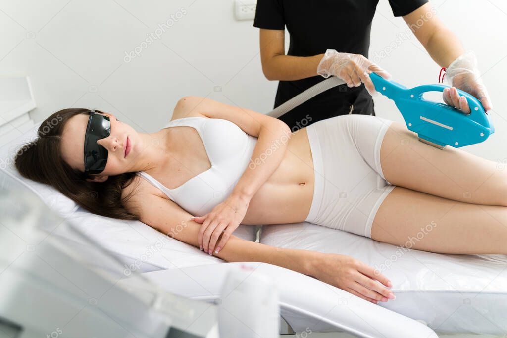 Attractive woman with beautiful smooth skin removing hair body with laser and pulsed light at the clinic