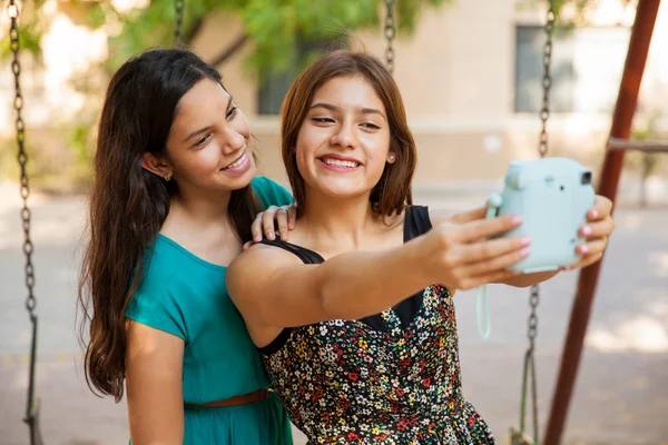 Amigos tomando una selfie con una cámara instantánea — Foto de Stock