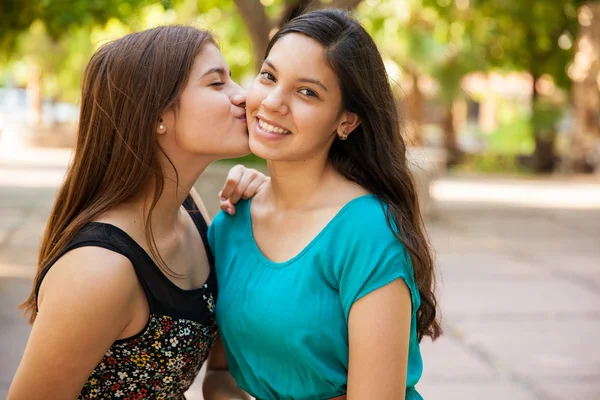 Teen kissing her friend in  cheek — Stock Photo, Image