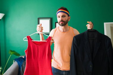 Kimliğime saygı ve kabullenme. Üzgün gay, cinsiyeti belirsiz, kadın ve erkek kıyafetleri tutan kişi. 