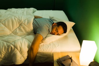 Yoruldum artık. Yorgun genç bir adam yüzüstü yatar ve yatak odasında mışıl mışıl uyur.