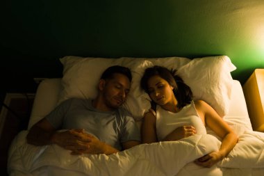 Geceyi birlikte geçirmeyi seviyoruz. Rahat bir yatakta uyuyan İspanyol bir çiftin en iyi görüntüsü.  