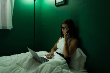 Geç saatlere kadar çalışıyorum. Akıllı kadın telefonda konuşuyor ve gece yarısı yatağında bilgisayarında daktilo yazıyor.