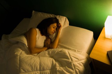 Uzun bir günün ardından dinleniyorum. Yorgun genç bir kadın yan yatıp iyi bir uyku çekiyor.