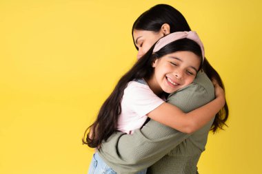Seni o kadar çok seviyorum ki. Tatlı İspanyol kız güzel annesine sarılıyor ve gülümsüyor. 