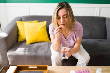 Hasta yaşlı kadın sabahları evde günlük haplarını ve vitaminlerini alıyor. 