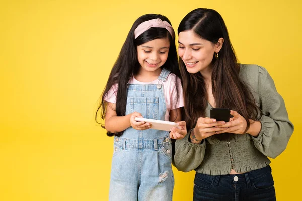 Lycklig Mor Och Ung Dotter Tittar Sina Telefoner Medan Tittar — Stockfoto