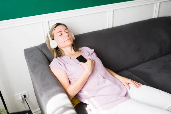 Mujer Mayor Tranquila Sus Años Sentada Sofá Escuchando Una Música — Foto de Stock