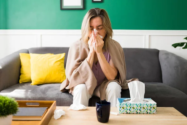 患流感的生病老年妇女呆在家里 一个患感冒 鼻子被打的成熟女人 — 图库照片