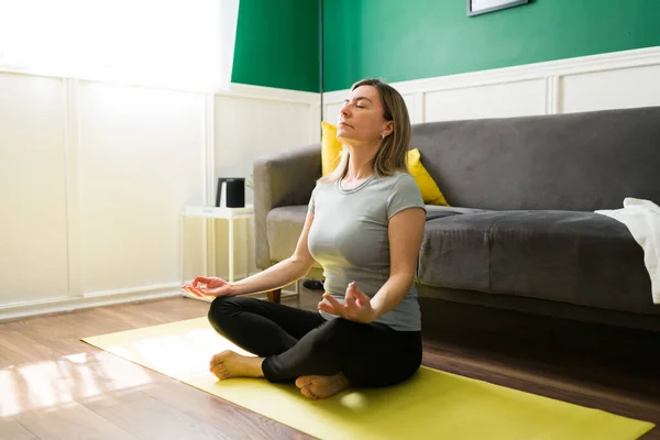 Avslappnad Mogen Kvinna Aktiva Kläder Gör Andningsövningar Och Utövar Yoga — Stockfoto