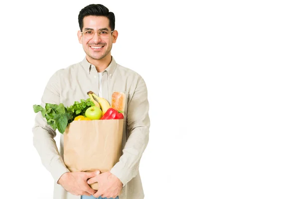 Latinky Pohledný Muž Drží Sáček Potravinami Usmívá Při Pohledu Očí — Stock fotografie