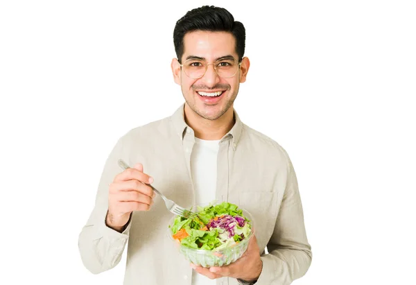 我有一个健康的饮食 快乐的男人微笑着 一边看着相机一边吃着一碗绿色沙拉 — 图库照片