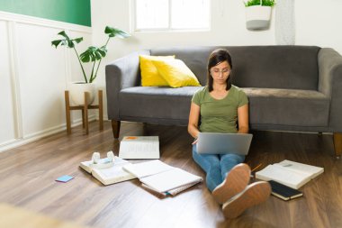 Sınavlarım için hazırım. Evde ödev yaparken ve üniversiteye çalışırken dizüstü bilgisayarda yazan zeki bir genç kadın.