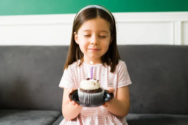 可爱的小女孩在生日那天许了个愿 然后吹灭了小巧克力蛋糕的蜡烛 — 图库照片