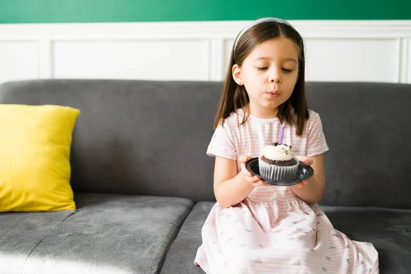 许个愿 可爱的小女生在家里庆祝一个派对 吹灭生日蛋糕的蜡烛 — 图库照片