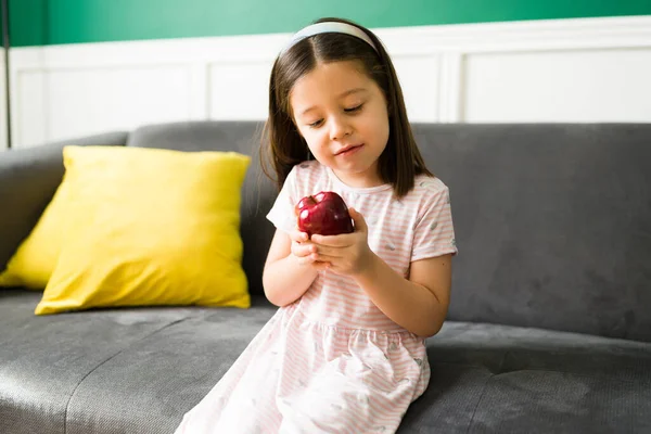 健康的小吃可爱的小孩坐在沙发上吃着美味的苹果 — 图库照片