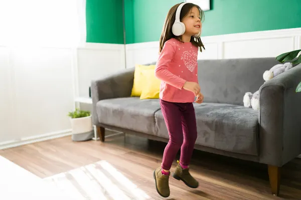 Podekscytowane Dziecko Noszące Słuchawki Bezprzewodowe Podczas Skakania Tańca Zabawy Szczęśliwa — Zdjęcie stockowe