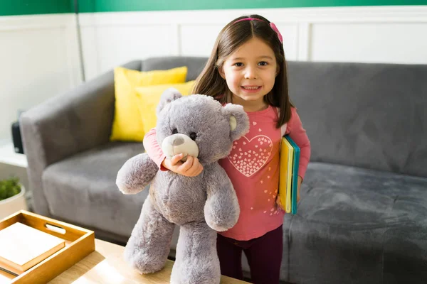 在闲暇的日子里 可爱的小女孩在家里玩玩具熊和彩色书籍 — 图库照片