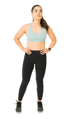 Spor kıyafetleri giyen ve güçlü bir antrenmana hazır aktif bir kadın.