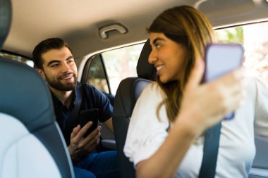 Mutlu kadın sürücü ve yolcu varış noktasına giderken akıllı telefondaki GPS 'e bakıyor.