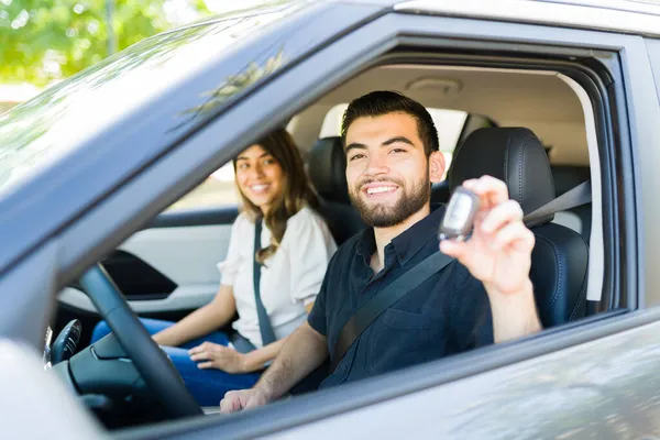 新しい車を購入した後 彼の鍵を示す魅力的な若い男 レンタカーを使用して陽気なカップル — ストック写真