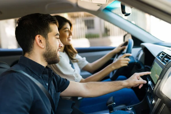 車のGpsシステムを使用して助手席にラテン語の若い男と女性の運転に指示を与える — ストック写真