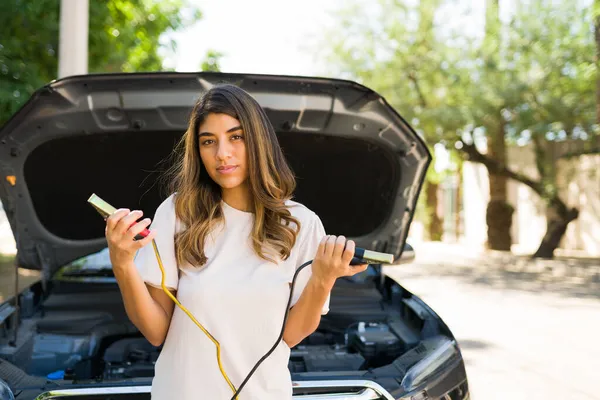 道端での支援を待っている 車のバッテリーの問題があった後 電源ケーブルを保持する魅力的な女性の肖像画 — ストック写真