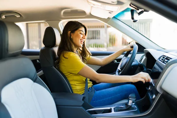 ラジオで音楽を聴きながら運転しながら車の中で歌う陽気な若い女性 — ストック写真