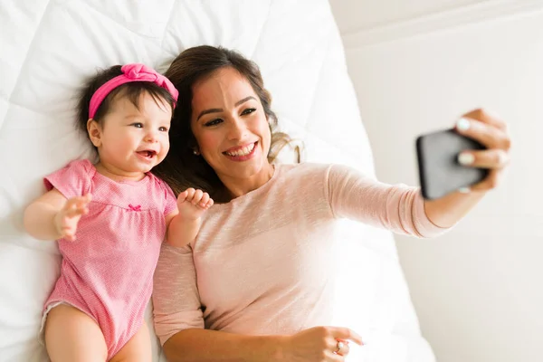 Çekici Anne Yatakta Dinlenirken Mutlu Küçük Kızıyla Selfie Çekiyor — Stok fotoğraf