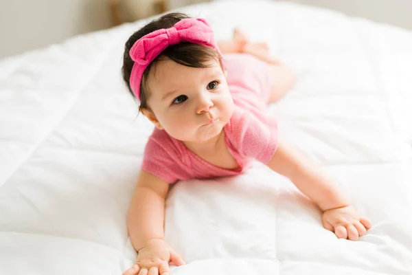 Piękny Uroczy Dziewczynka Nosi Różową Opaskę Onesie Podczas Pełzania Łóżku — Zdjęcie stockowe