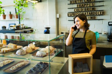 Kahve dükkanında müşteri siparişi veren mutlu bayan barista.