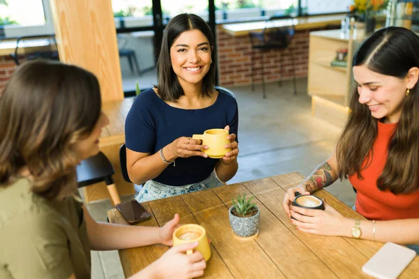 魅力的なラテン語の若い女性は コーヒーを飲み 友人とテーブルで彼らの食べ物の注文を待っています — ストック写真