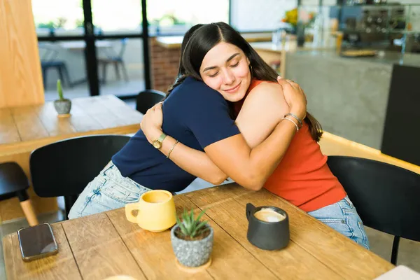 Quiero Mucho Encantadoras Amigas Abrazándose Sonriendo Mientras Están Sentadas Restaurante —  Fotos de Stock