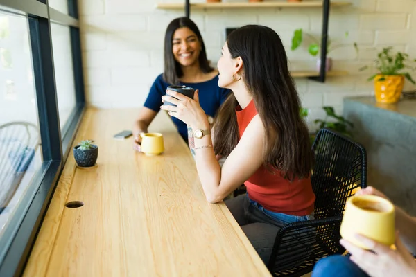 快乐的年轻女人和最好的朋友一边喝咖啡一边聊天 — 图库照片
