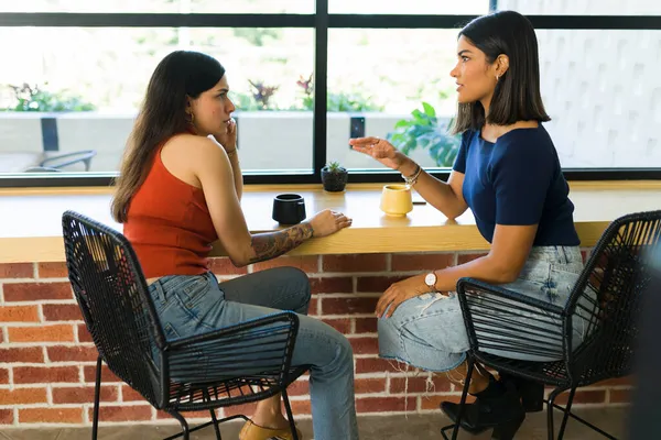 女性最好的朋友赶上并进行了深入的对话 在咖啡店聊天的年轻女人 — 图库照片