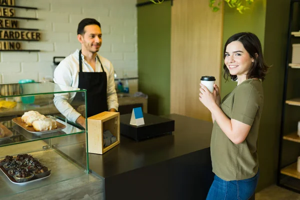 Genç ve güzel bir kadın, yerel kahve dükkanından kahve ısmarladıktan sonra kendini mutlu ve tatmin olmuş hissediyor.