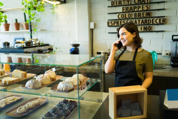 Kahve dükkanında müşteri siparişi veren mutlu bayan barista.