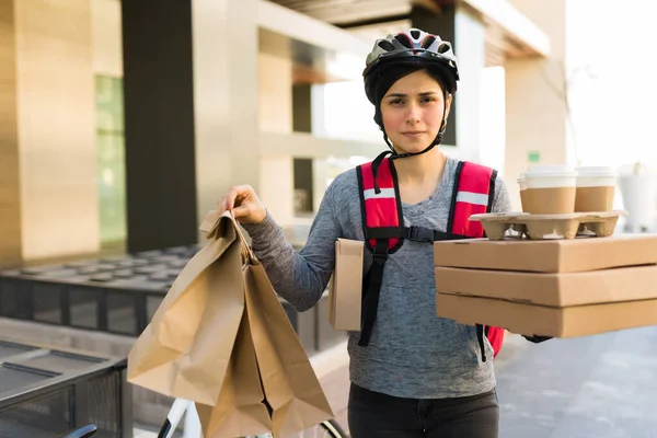 街で多くの配達を行うために食べ物の注文の多くを拾う自転車の上に疲れて配達の女の子 — ストック写真