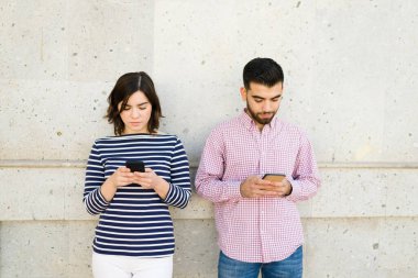 Kızgın çift, birbirlerine kızgın ve akıllı telefonu kullanıyorlar. Çekici kadın ve dışarıda mesajlaşan genç adam.