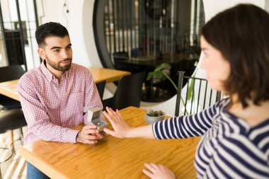 Üzgün genç bir adam kız arkadaşına evlenme teklif ediyor. Kızgın genç kadın erkek arkadaşından aldığı elmas yüzüğü reddediyor.