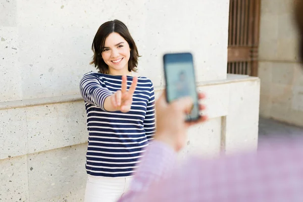 Attractive Young Woman Making Peace Sign Photo Boyfriend Taking Picture — Stock Photo, Image