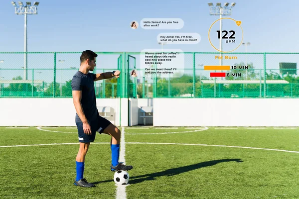 活跃的男人在足球场上锻炼 一边看着自己的聪明 一边使用3D虚拟模拟健康应用程序 一边发短信 — 图库照片