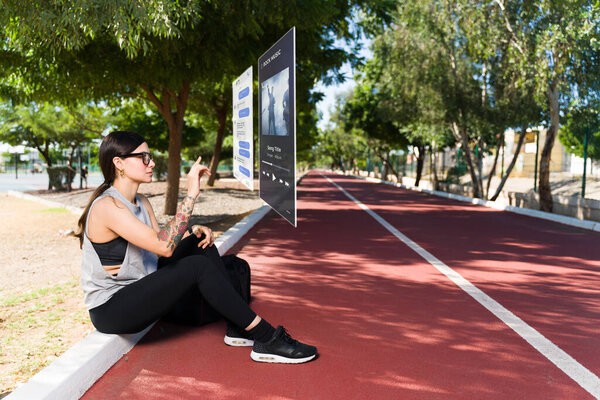 Virtual reality technology. Young woman resting from a workout and texting using augmented reality 