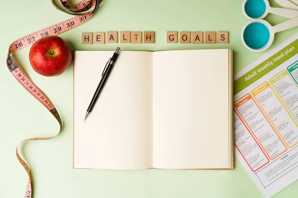 健康目标 平躺在笔记本上 开始和营养师一起写降的饮食来减肥 — 图库照片