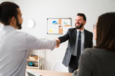 Very nice to meet you. Happy financial agent meeting a young woman and man while talking about a new loan