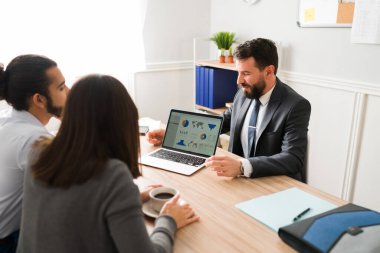 This is the best investment plan. Financial agent giving advice about credits and loans to a couple at his office 