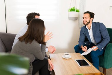 Handsome finance advisor having a meeting with clients at their home to talk about investment plans 