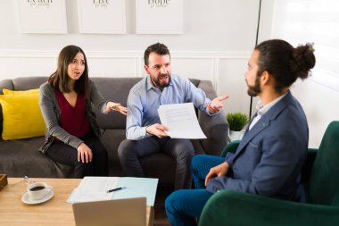 Kızgın çift bir menajerle tartışıyor ve ellerinde yasal belgeler varken emlak dolandırıcılığına yatırım yaptıkları için kendilerini aldatılmış hissediyorlar.